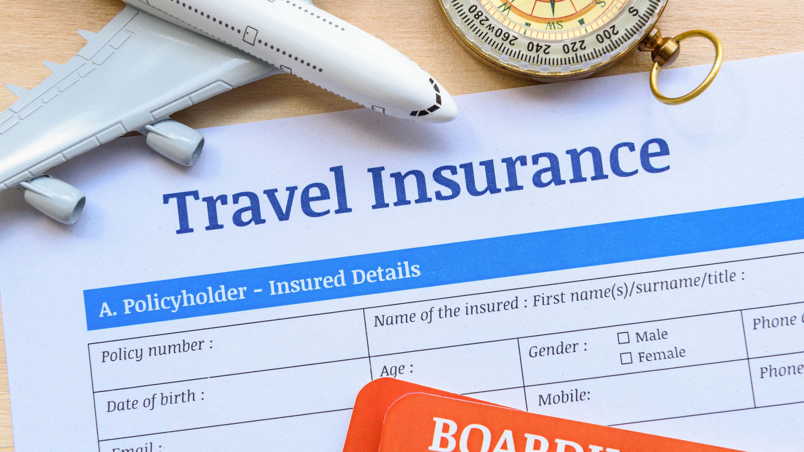 a travel insurance form with a compass and airplane